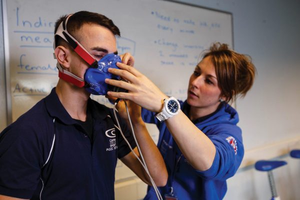 A sports student wears sport science equipment which monitors performance whilst exercising