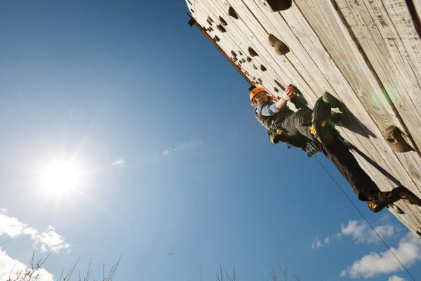 Woman on a climbing tower in sunshine and blue skies