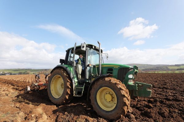 Student sitting in a tractor in a ploughed field