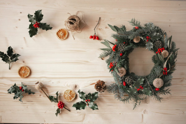 A contemporary Christmas wreath with holly, dried fruit and twine