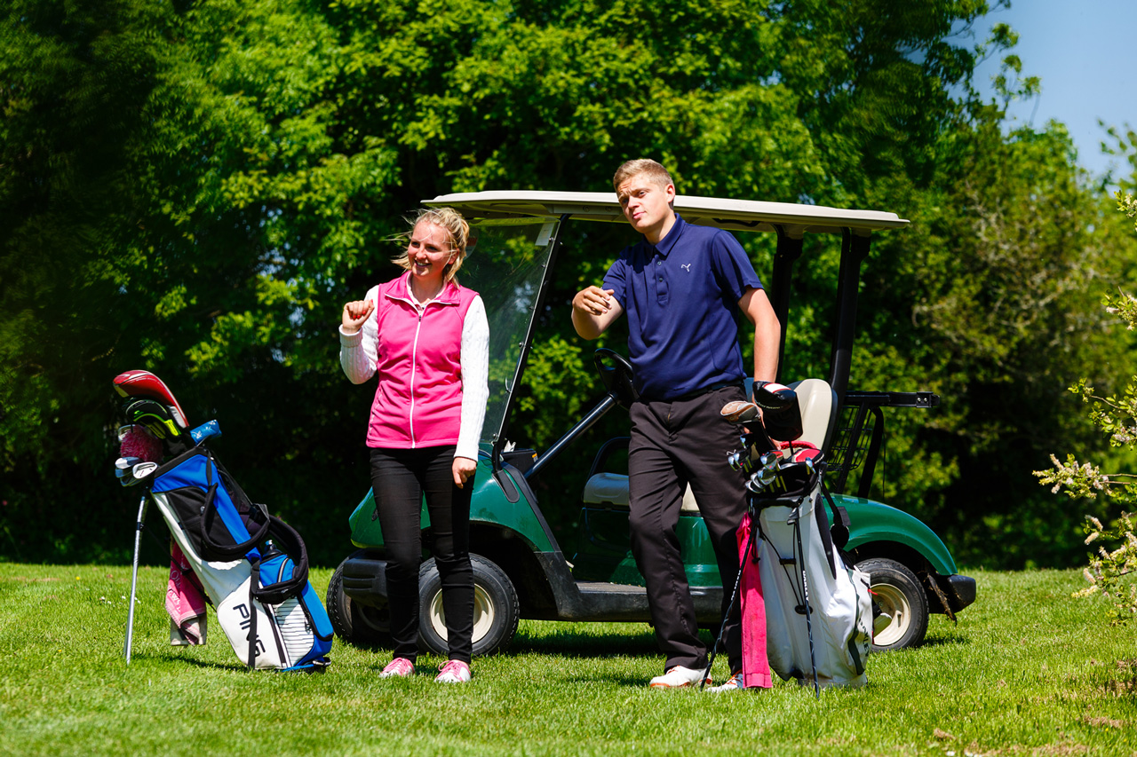 Golf students by a caddy