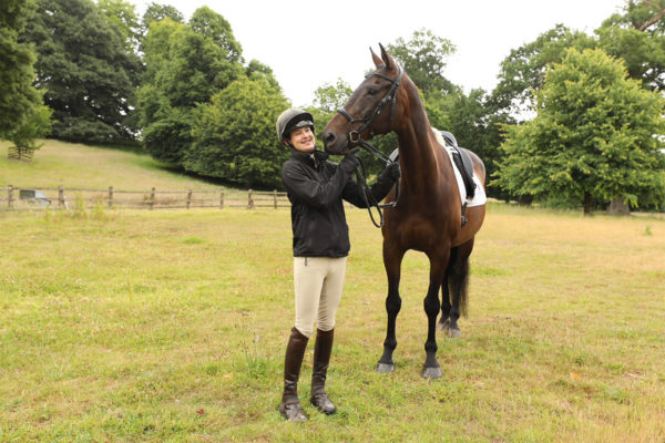A Bicton equine student outside in a field with a horse