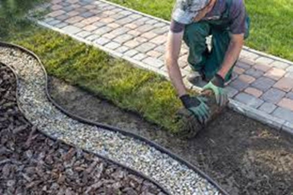 Landscape gardener lays turf and a gravel pathway